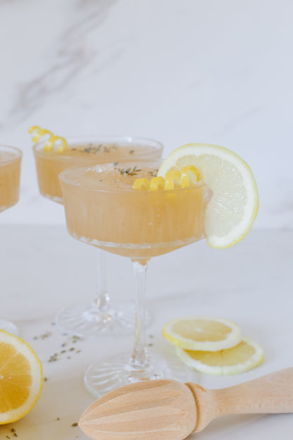 Lush Lavender Lemon Slushie with a twisted lemon garnish, offering a refreshing and aromatic frozen drink experience.






