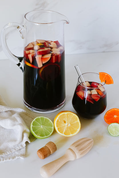 Lush Sangria Slushie served in a wine glass with a pitcher, showcasing a vibrant, fruity frozen drink ideal for sharing.






